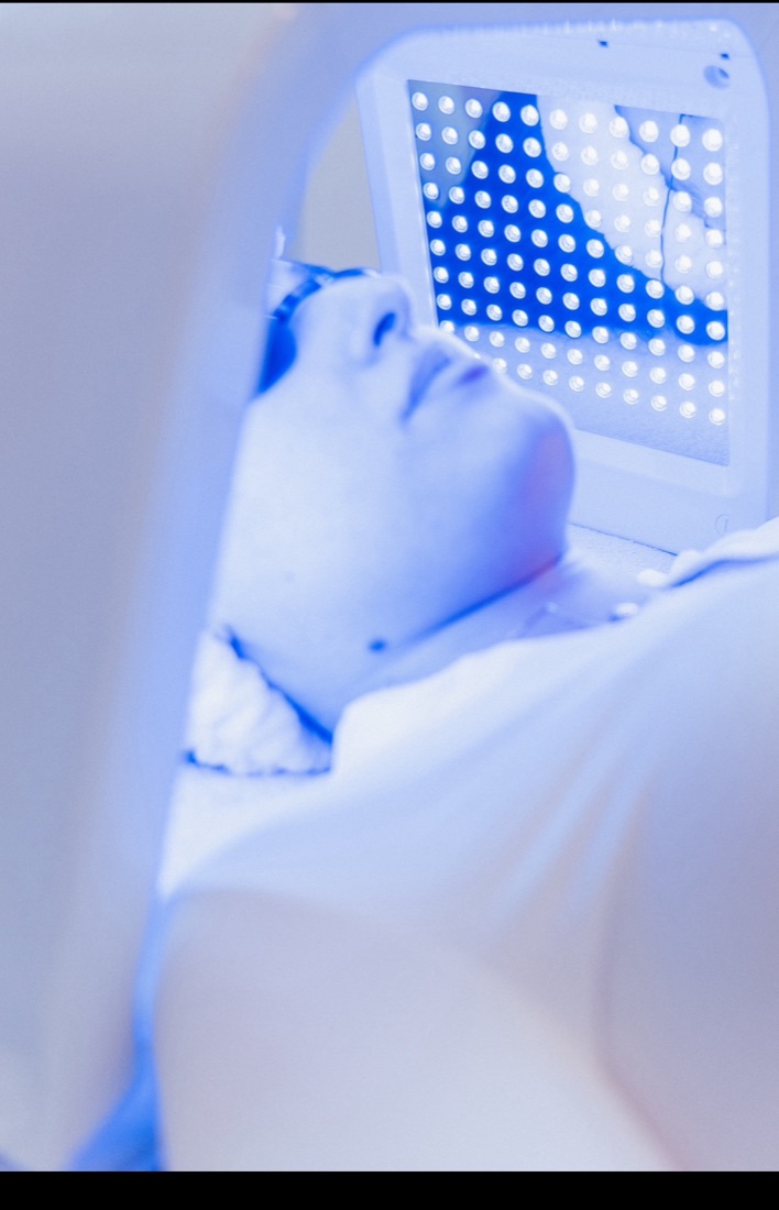 Client under an LED light therapy panel